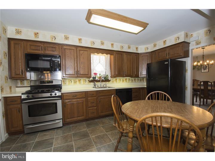 17 Braeburn Road Havertown, PA 19083 - Photo 9 of 25 a kitchen with stainless steel appliances granite countertop a stove a refrigerator a sink a stove a dining table and chairs