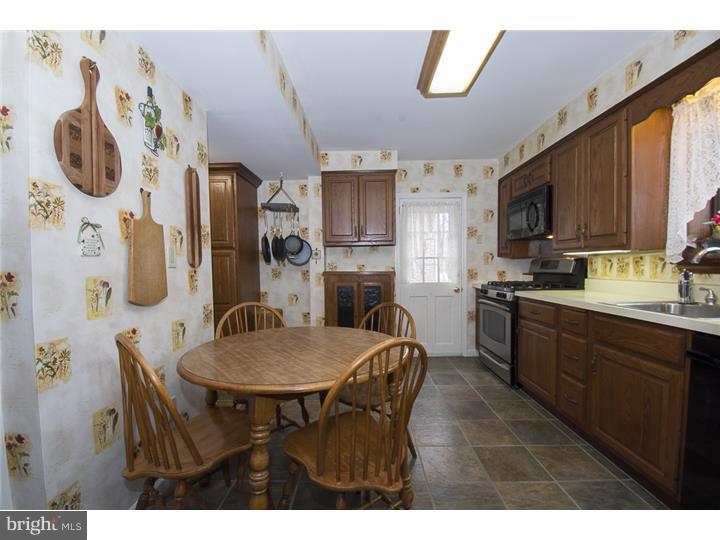 17 Braeburn Road Havertown, PA 19083 - Photo 10 of 25 a kitchen with stainless steel appliances granite countertop a dining table chairs and a refrigerator