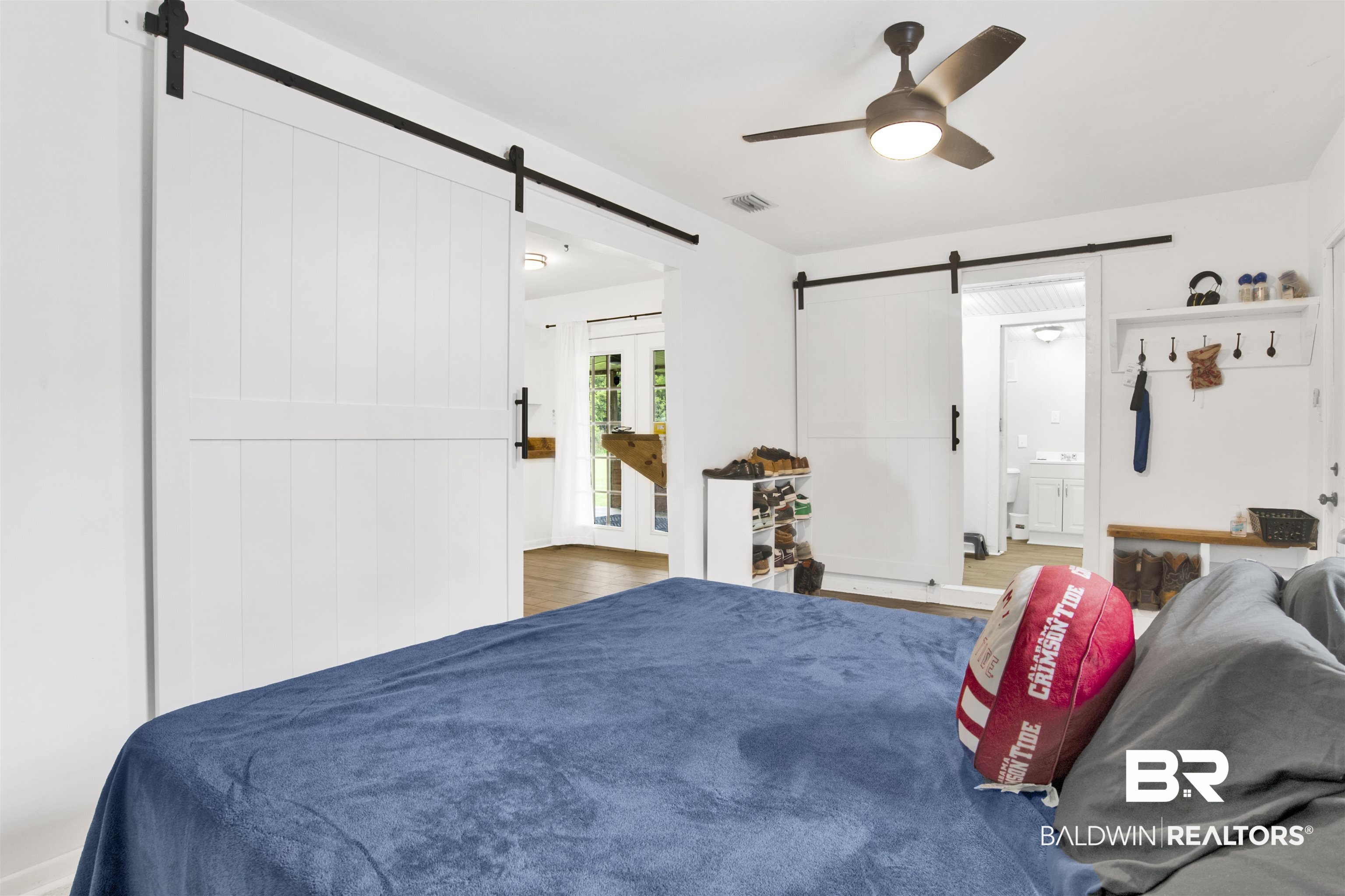 10244 Magnolia Road Irvington, AL 36544 - Photo 18 of 37 Bedroom featuring a ceiling fan, wood finished floors, a barn door, and visible vents
