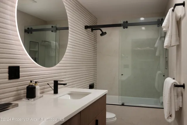 a kitchen with granite countertop a sink stainless steel appliances a large window and a counter top space