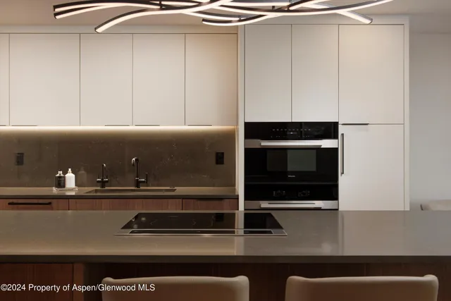 a kitchen with a table chairs refrigerator and microwave