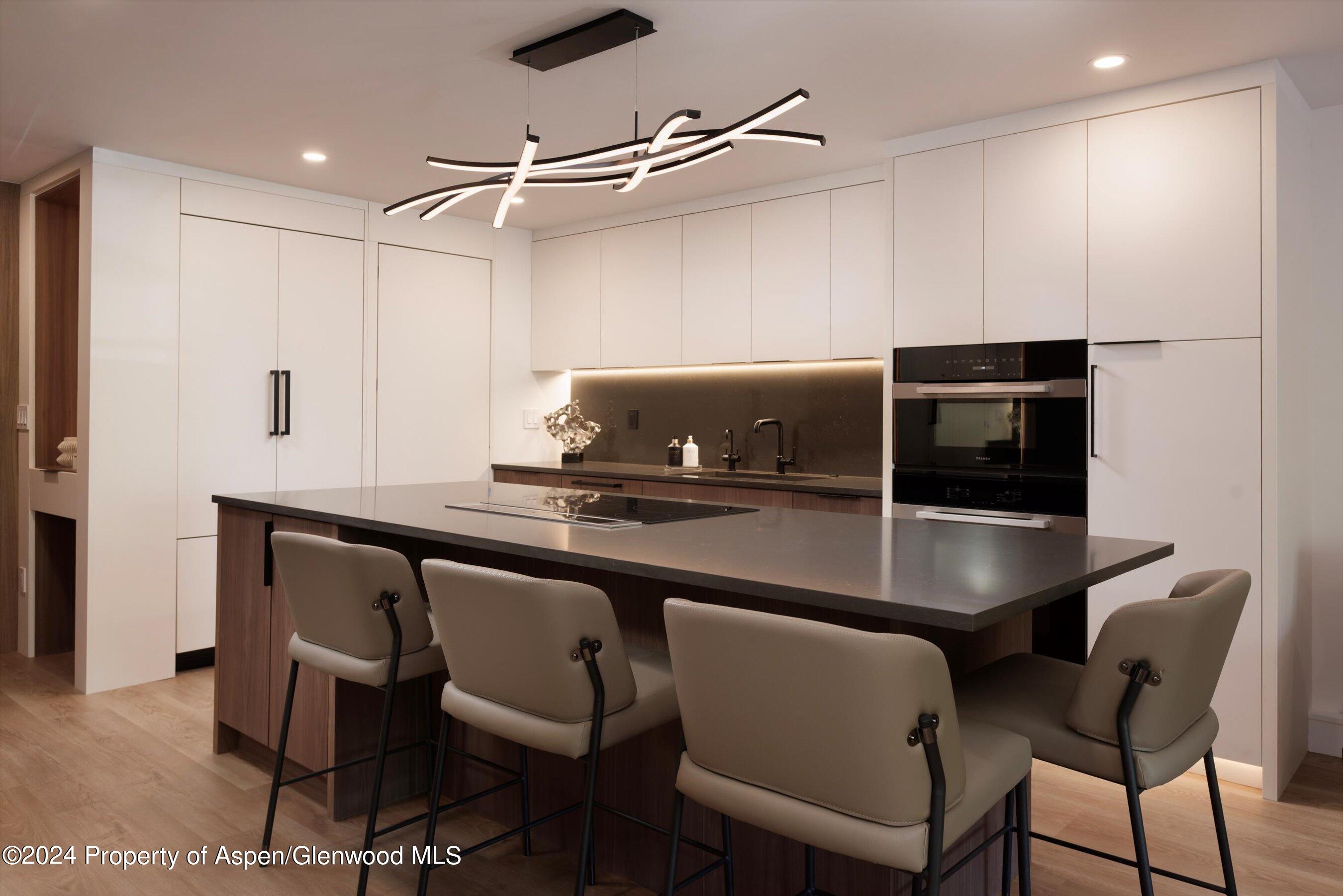205 East Durant Avenue, Unit 1I Aspen, CO 81611 - Photo 15 of 45 a kitchen with a table chairs refrigerator and microwave