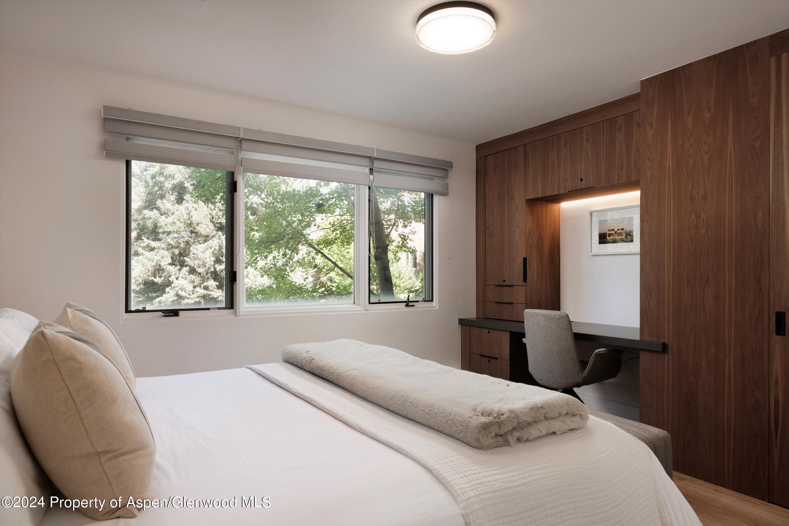 205 East Durant Avenue, Unit 1I Aspen, CO 81611 - Photo 16 of 45 a bedroom with a bed and large windows