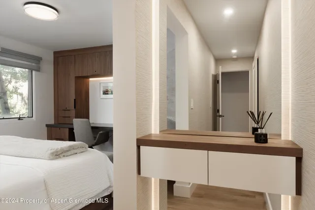 a bedroom with a bed a mirror and a window