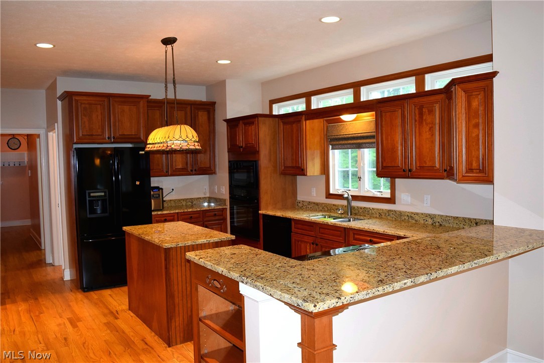 17000 Wing Road Chagrin Falls, OH 44023 - Photo 7 of 35 Eat-in Kitchen from the eating area reveals Hardwood floors, Breakfast bar, Granite counters and hallway at left to 1/2 bath, Laundry, 3 car garage and side porch to driveway.