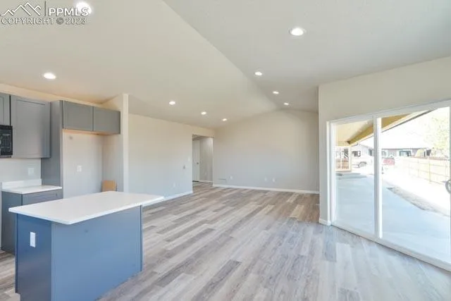 a view of kitchen with refrigerator and wooden floor