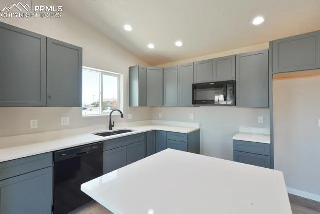 a kitchen with stainless steel appliances a sink a stove a refrigerator a center island and a window