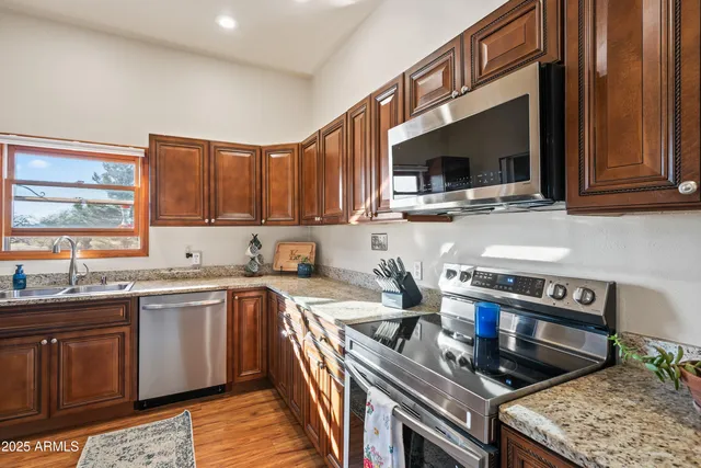 a kitchen with stainless steel appliances granite countertop a sink stove and microwave