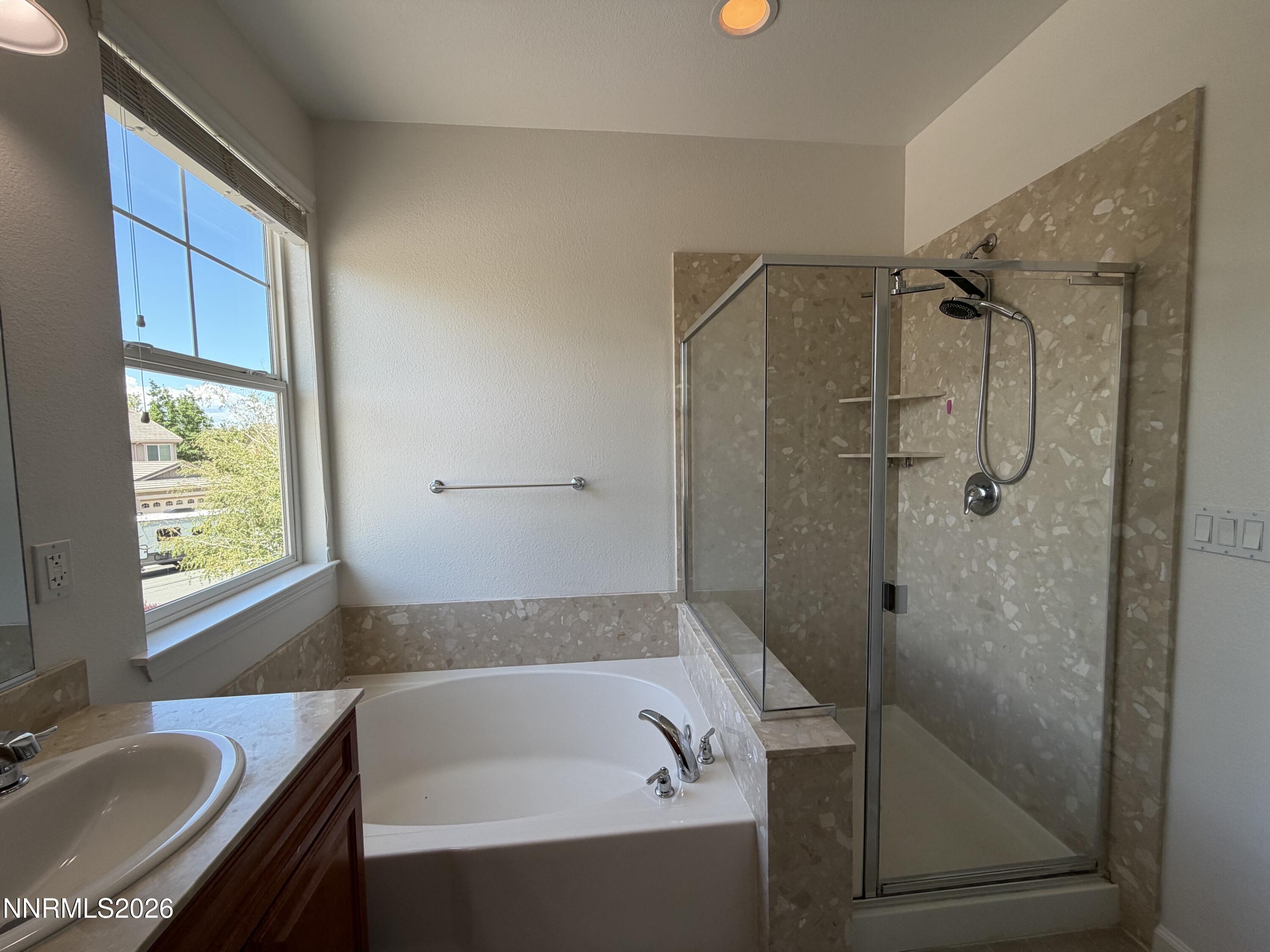 10890 Oakhaven Drive Reno, NV 89521 - Photo 11 of 28 a bathroom with a granite countertop sink a bathtub and shower