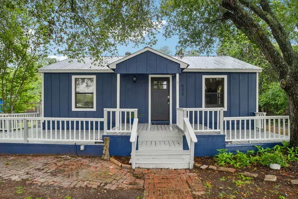 a view of a house with a small yard and wooden fence