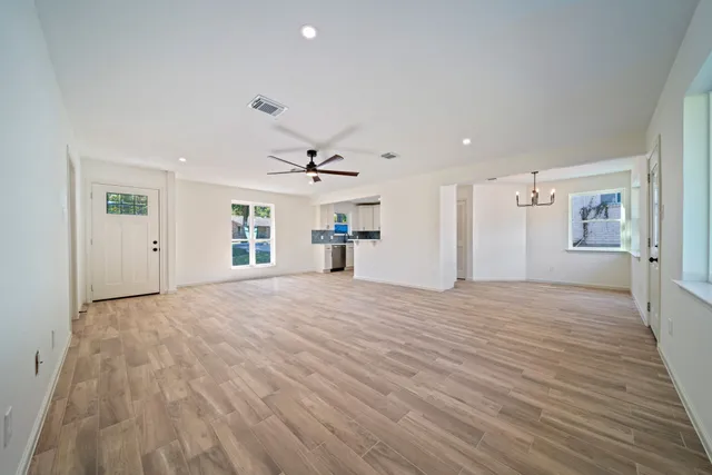 a view of a livingroom with wooden floor and a ceiling fan