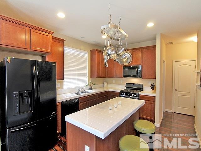 11615 Verazae Drive Reno, NV 89521 - Photo 5 of 25 a kitchen with a refrigerator a sink cabinets and wooden floor