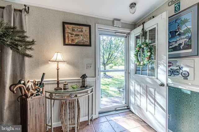 a kitchen with furniture a potted plant and a large window