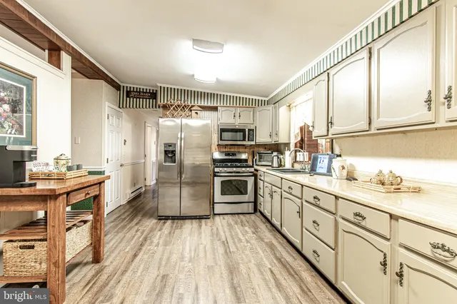 a kitchen with stainless steel appliances a stove sink and refrigerator