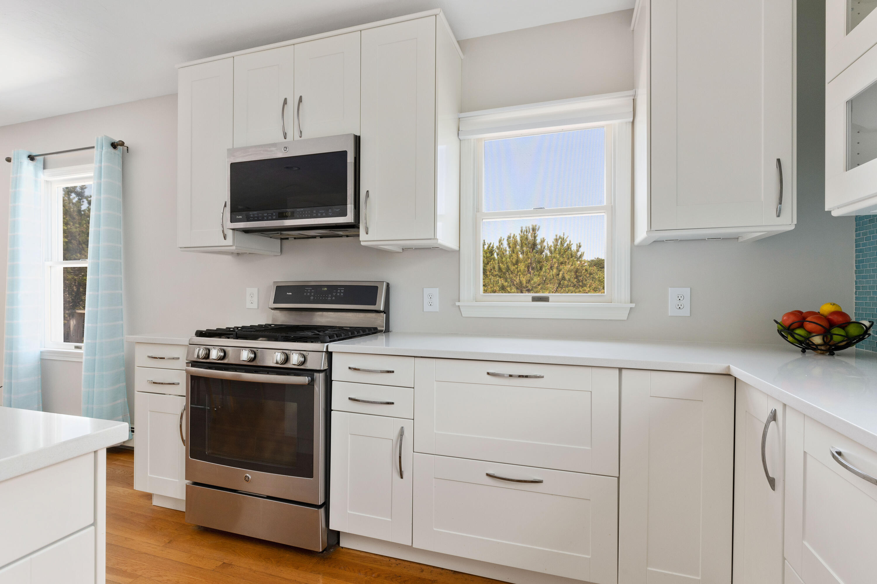 5 Starbuck Road Truro, MA 02666 - Photo 18 of 46 a kitchen with white cabinets and stainless steel appliances