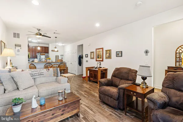 a living room with furniture kitchen view and a window