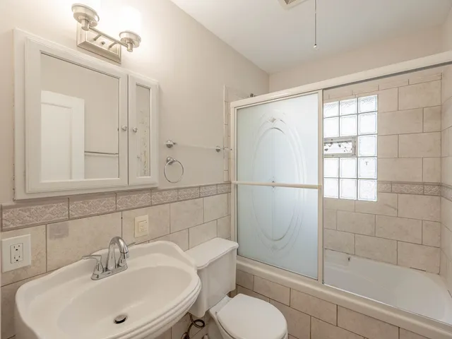 a bathroom with a sink a toilet and shower