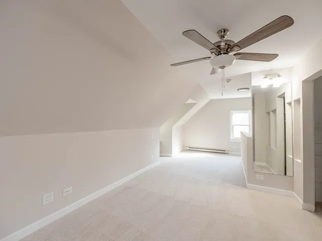 a view of a hallway with a chandelier fan and windows