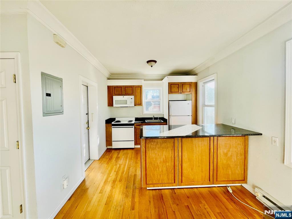 229 Orient Way, Unit 6 Rutherford, NJ 07070 - Photo 4 of 8 a view of a living room with kitchen and wooden floor