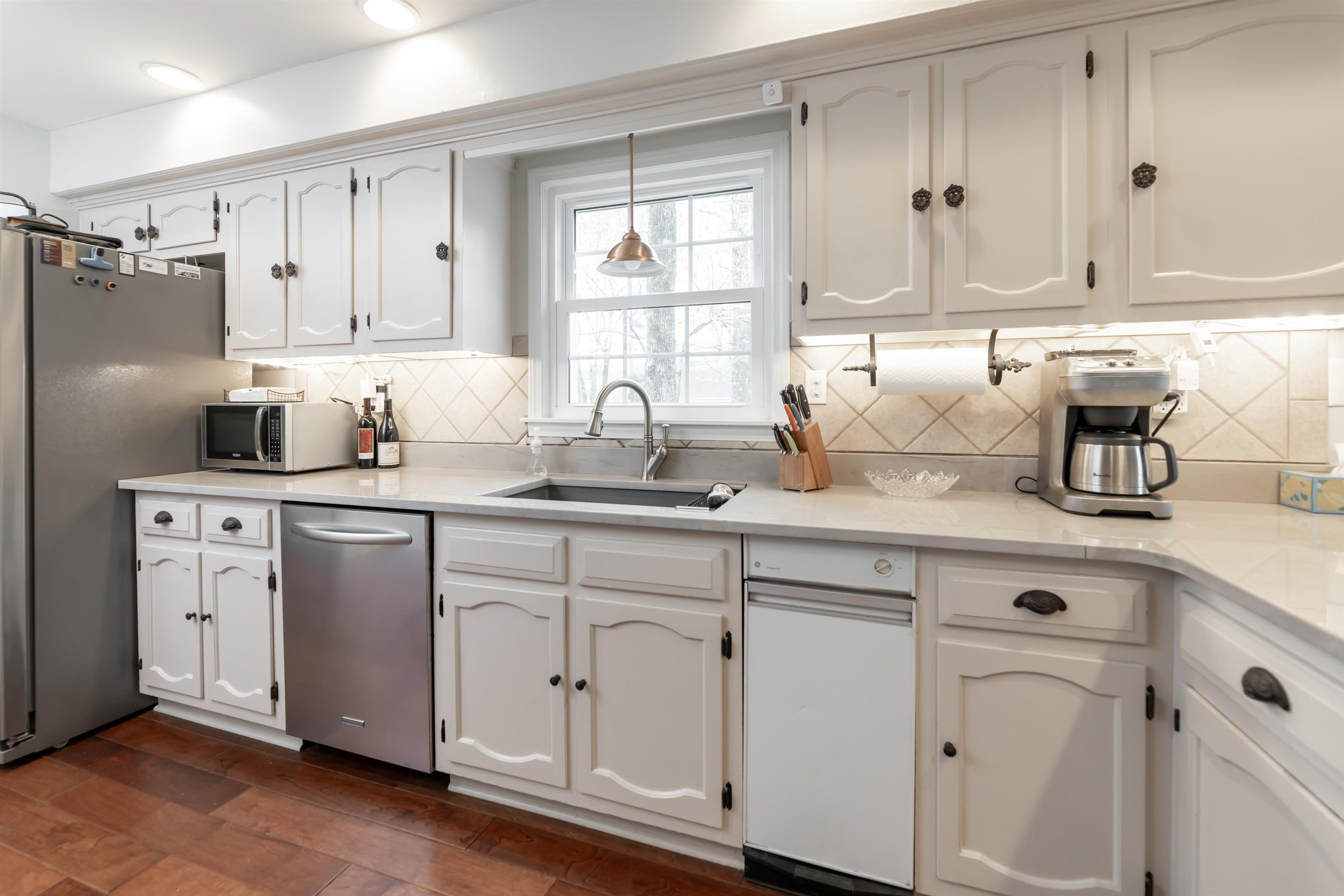 8441 Dogwood Road Germantown, TN 38139 - Photo 12 of 29 Kitchen featuring white cabinetry, stainless steel appliances, dark wood-style floors, light stone counters, and pendant lighting