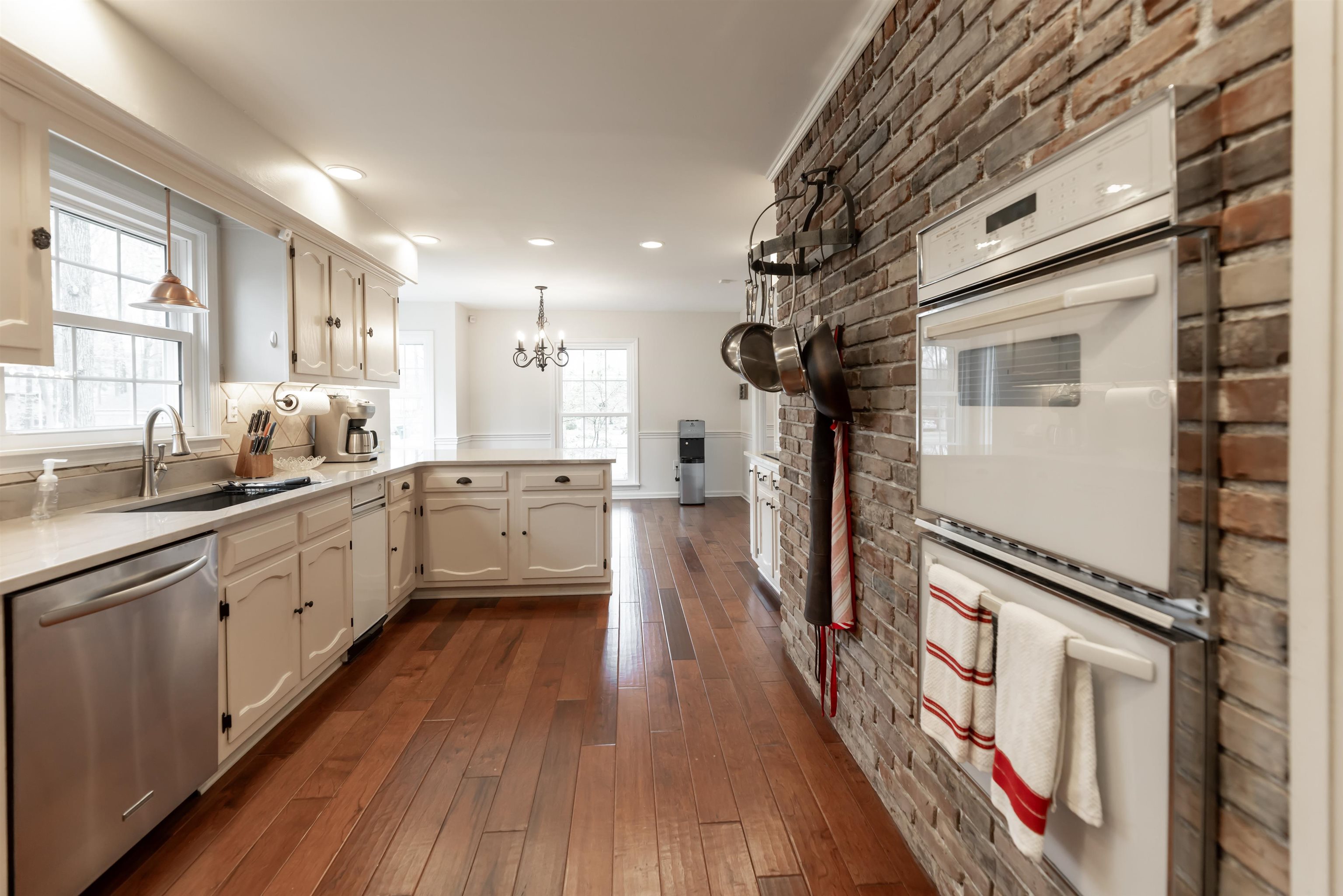 8441 Dogwood Road Germantown, TN 38139 - Photo 14 of 29 Kitchen with double oven, a peninsula, stainless steel dishwasher, dark wood-style flooring, and a chandelier