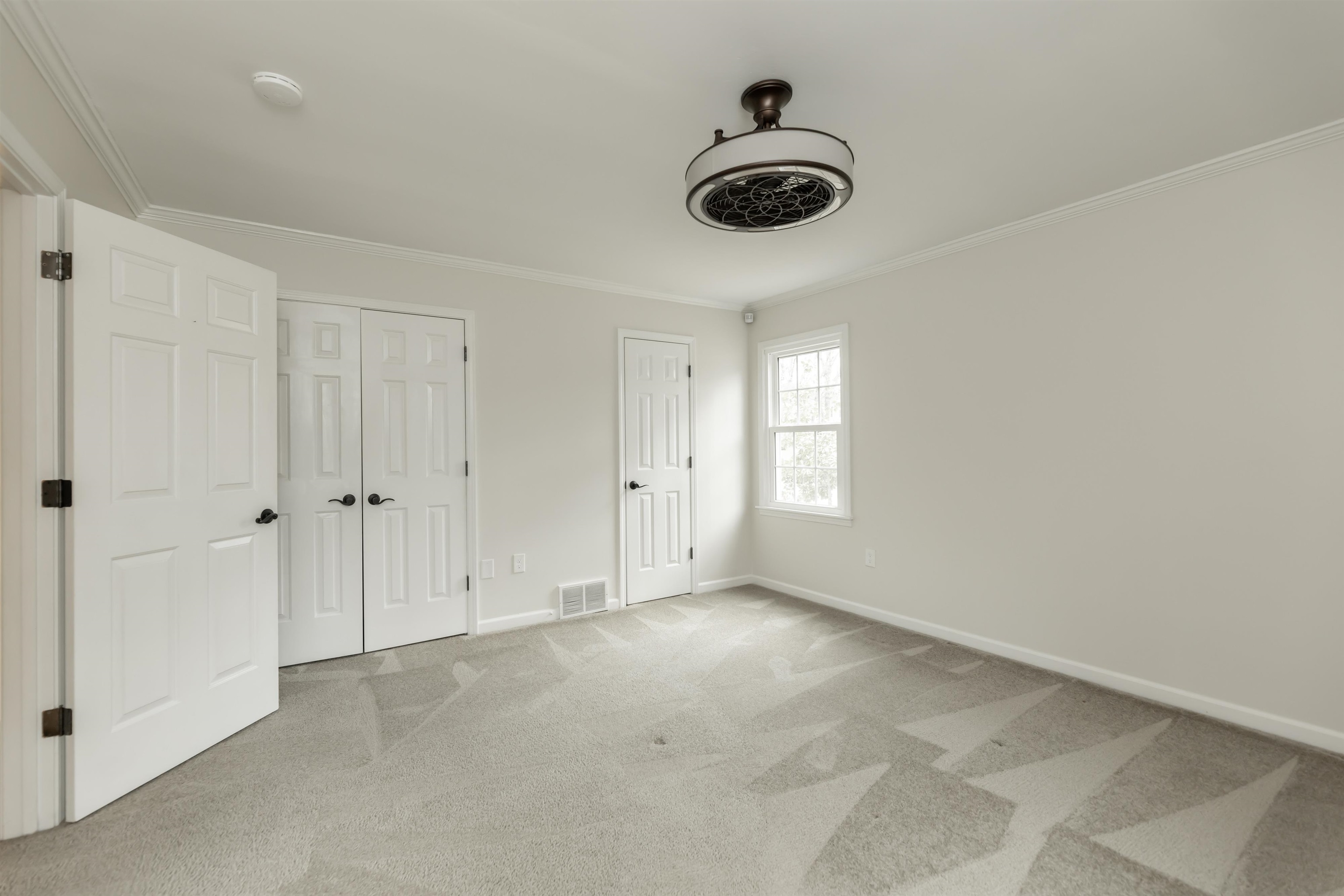 8441 Dogwood Road Germantown, TN 38139 - Photo 18 of 29 Unfurnished bedroom featuring light carpet, crown molding, and two closets