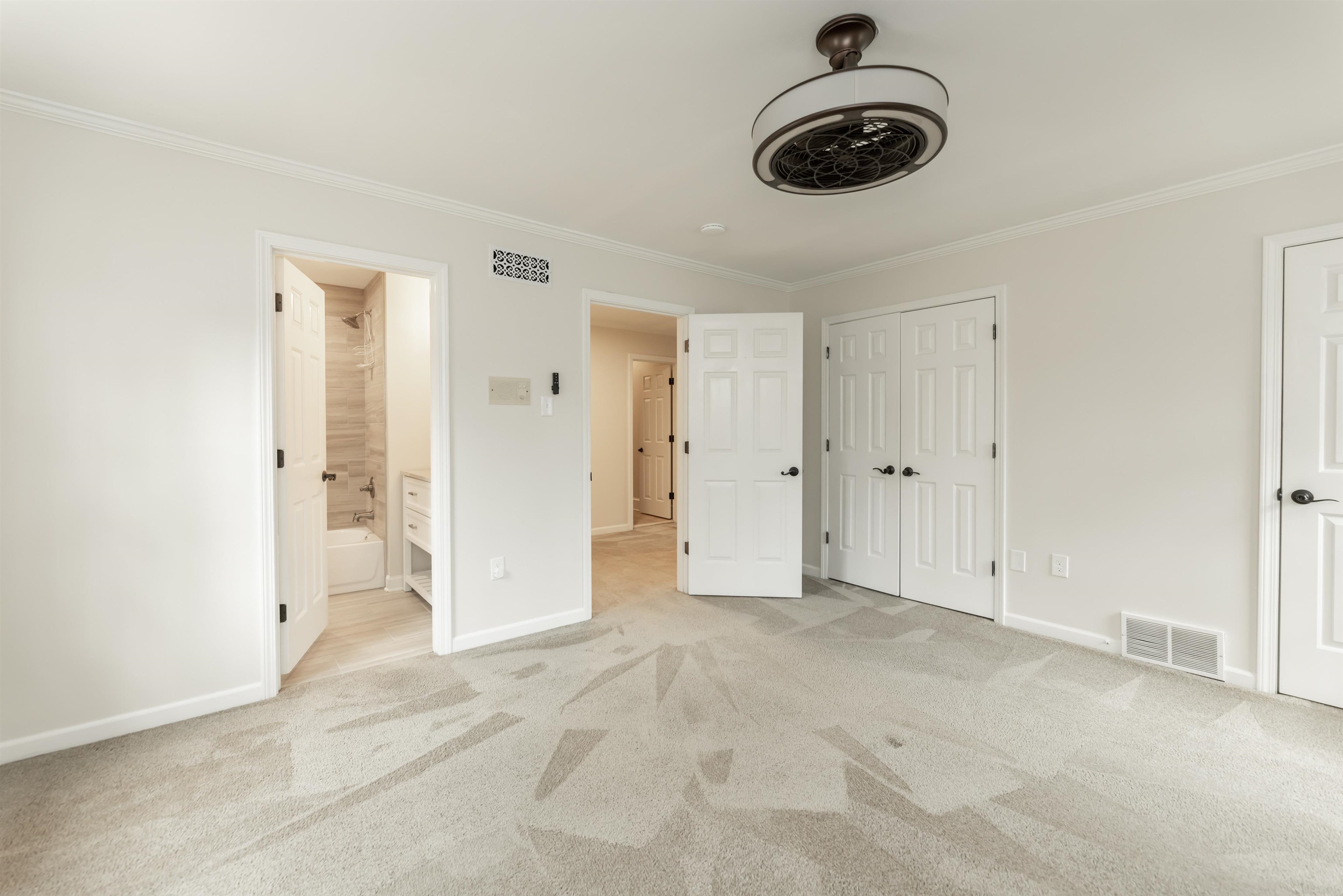 8441 Dogwood Road Germantown, TN 38139 - Photo 19 of 29 Unfurnished bedroom with light carpet, ornamental molding, ensuite bath, and a ceiling fan