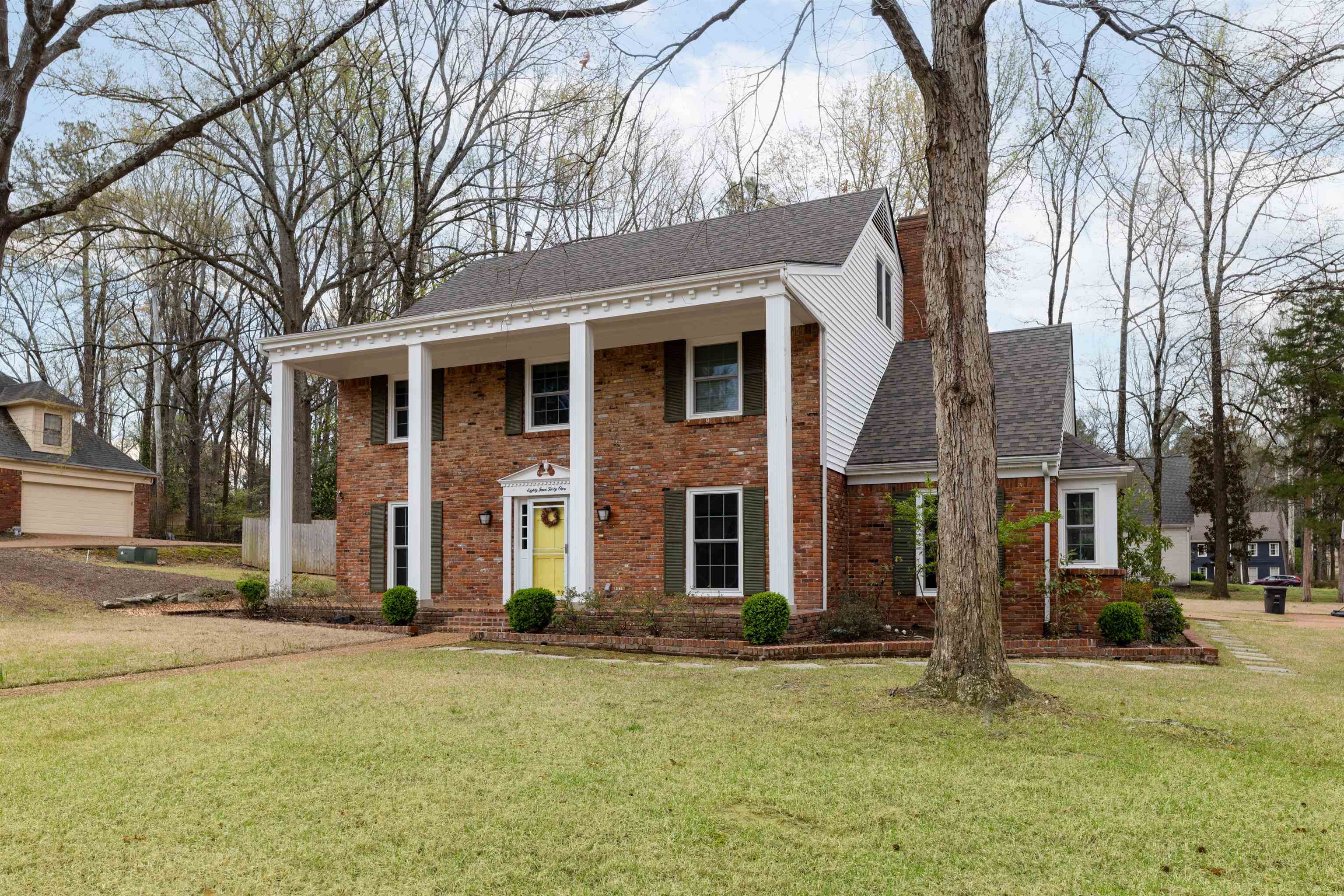 8441 Dogwood Road Germantown, TN 38139 - Photo 2 of 29 Greek revival house featuring a porch, roof with shingles, brick siding, and a front yard