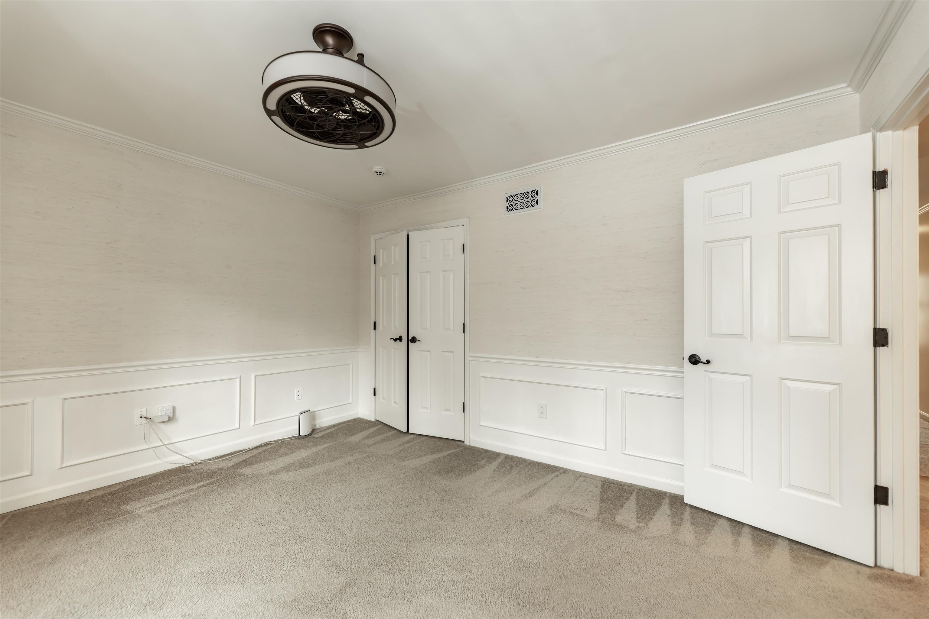 8441 Dogwood Road Germantown, TN 38139 - Photo 21 of 29 Unfurnished bedroom featuring a wainscoted wall, a decorative wall, light colored carpet, a closet, and crown molding
