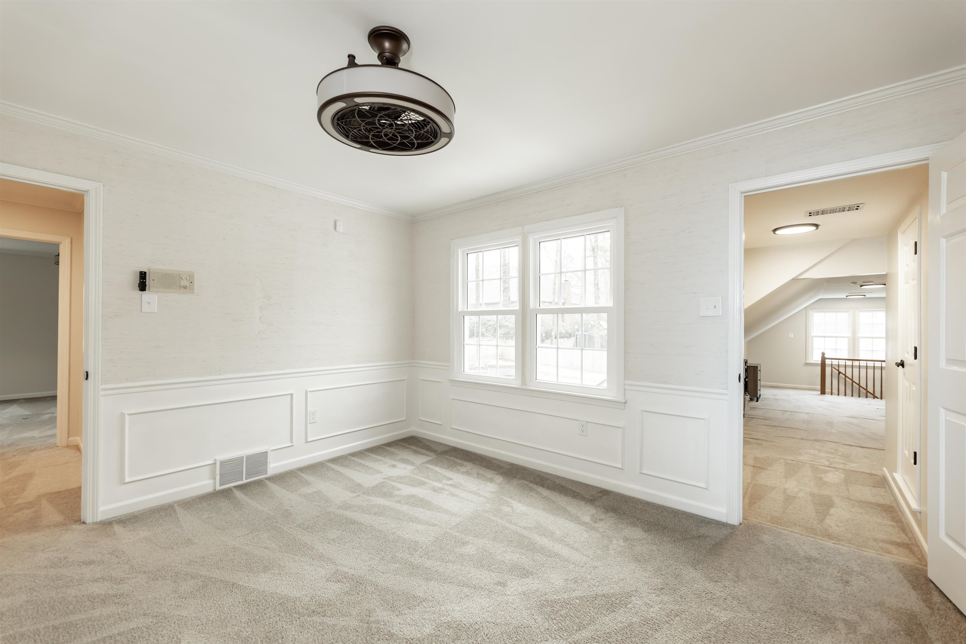 8441 Dogwood Road Germantown, TN 38139 - Photo 22 of 29 Empty room featuring light colored carpet, a decorative wall, wainscoting, and crown molding