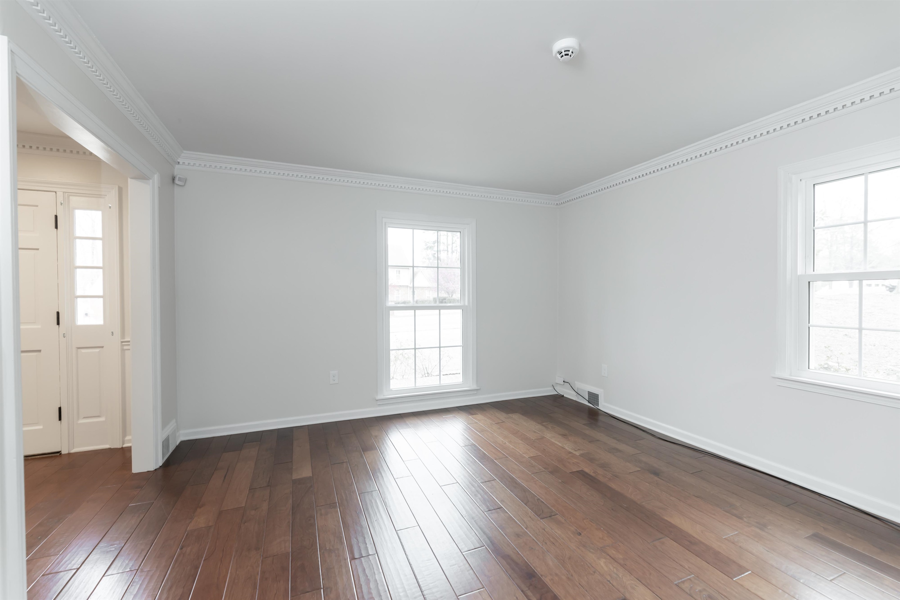 8441 Dogwood Road Germantown, TN 38139 - Photo 4 of 29 Empty room featuring crown molding, dark wood finished floors, and plenty of natural light