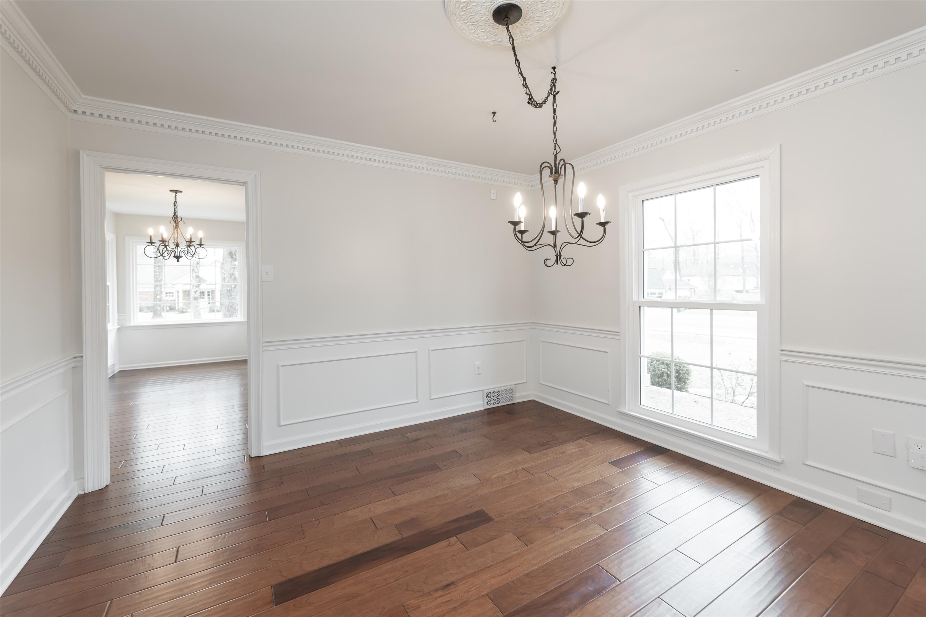 8441 Dogwood Road Germantown, TN 38139 - Photo 7 of 29 Unfurnished dining area with hanging lights, wainscoting, dark wood-style flooring, a decorative wall, and ornamental molding