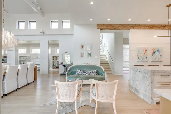 a kitchen with stainless steel appliances kitchen island granite countertop a table chairs sink and cabinets