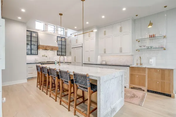 a kitchen with kitchen island stainless steel appliances a sink and a refrigerator