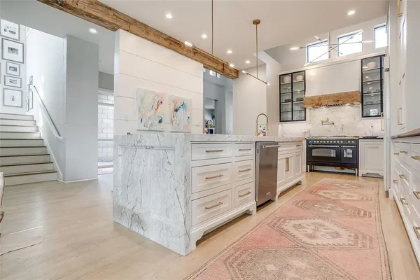 a kitchen with stainless steel appliances kitchen island granite countertop a stove a sink and a refrigerator