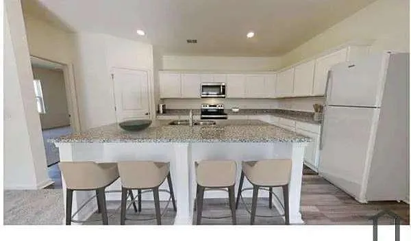 a kitchen with granite countertop cabinets and refrigerator