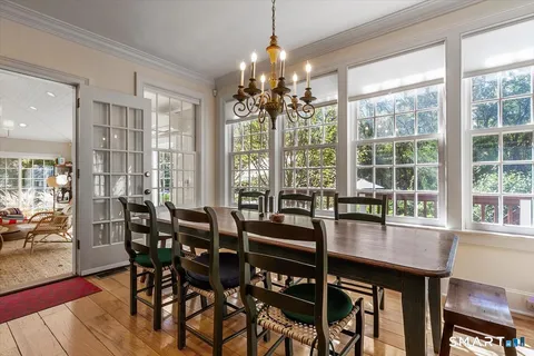 a dining room with furniture window chairs and wooden floor