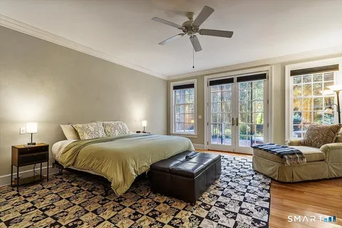 a bedroom with a bed couch and a large window