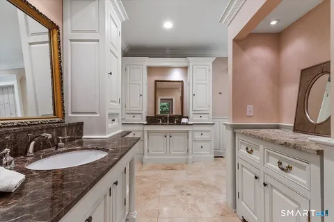 a bathroom with a granite countertop sink double vanity and a mirror