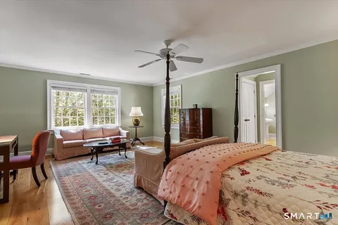 a bedroom with a bed couch and a window