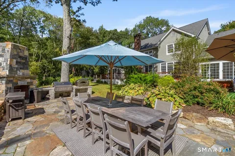 a view of a patio with furniture and table under an umbrella