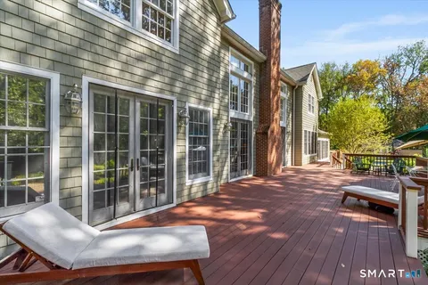 a view of backyard with deck and outdoor seating