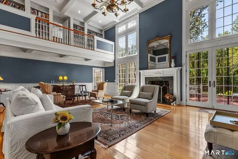 a living room with furniture fireplace and a large window