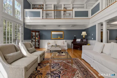 a living room with furniture wooden floor and a large window