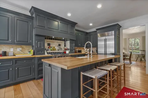 a kitchen with stainless steel appliances granite countertop a sink a stove and a refrigerator