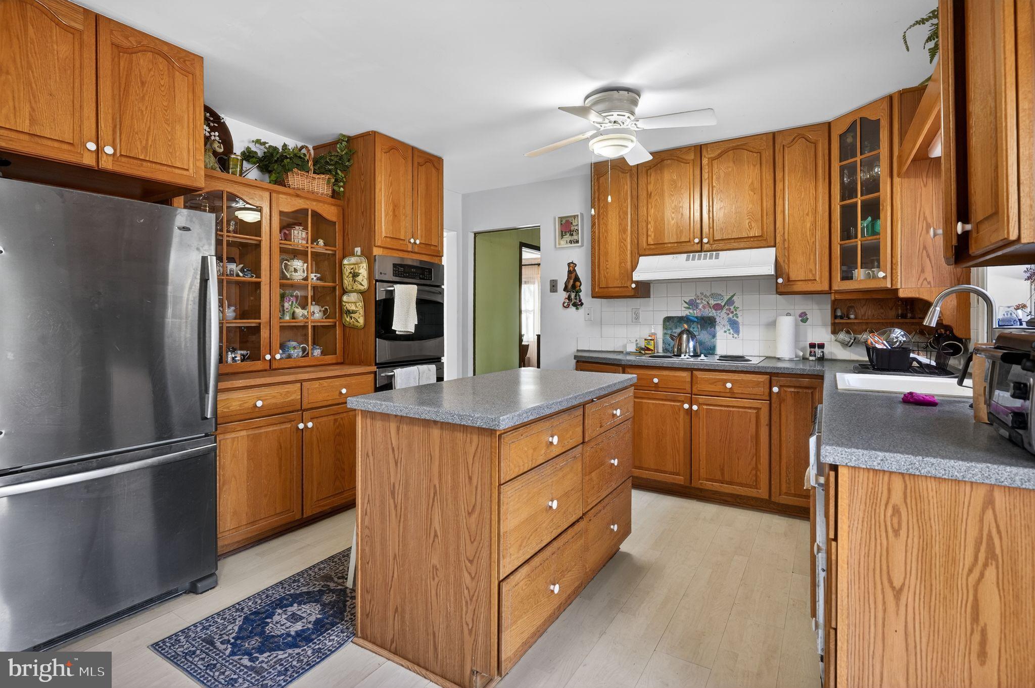 1725 Tarrytown Avenue Crofton, MD 21114 - Photo 16 of 39 a kitchen with stainless steel appliances granite countertop a refrigerator a sink dishwasher a stove with wooden cabinets and floor