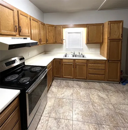 a kitchen with granite countertop a stove sink and cabinets
