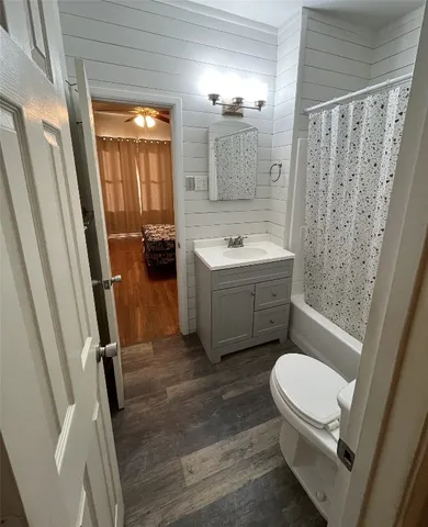 a bathroom with a sink a toilet a mirror and shower