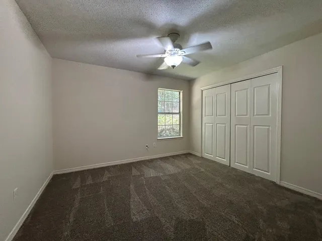 a view of staircase with lots of frames on wall and wooden floor