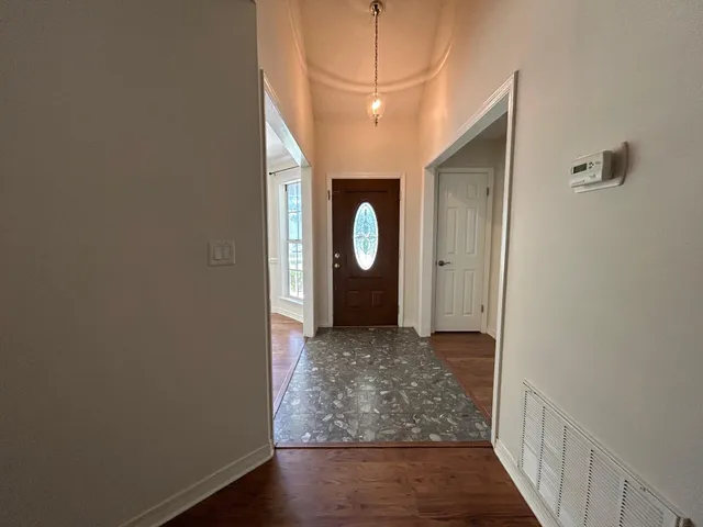 a view of a room that has a large window and wooden floor
